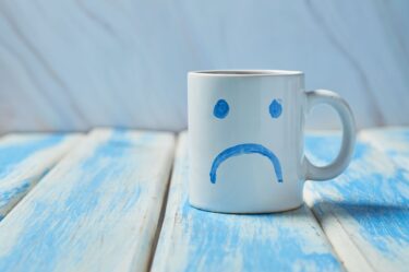 Blue monday, cup of coffee with a sad face.